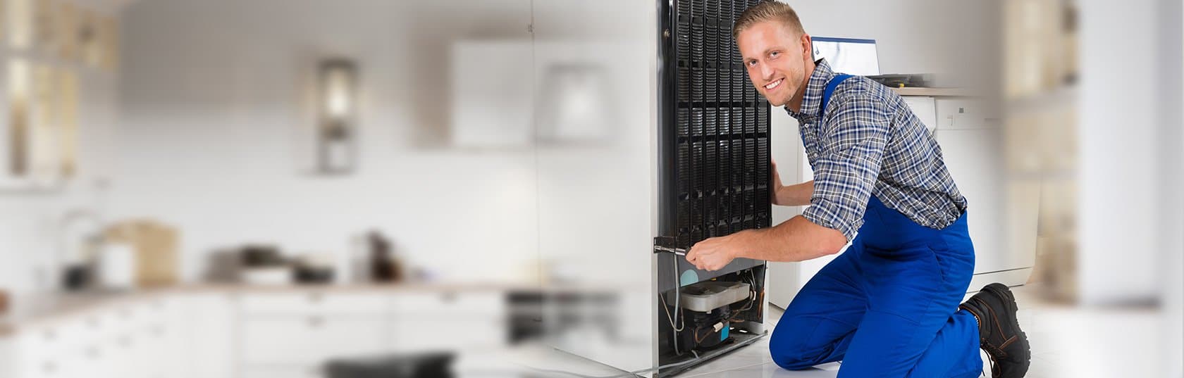 A man is smiling while holding the back of an old computer.